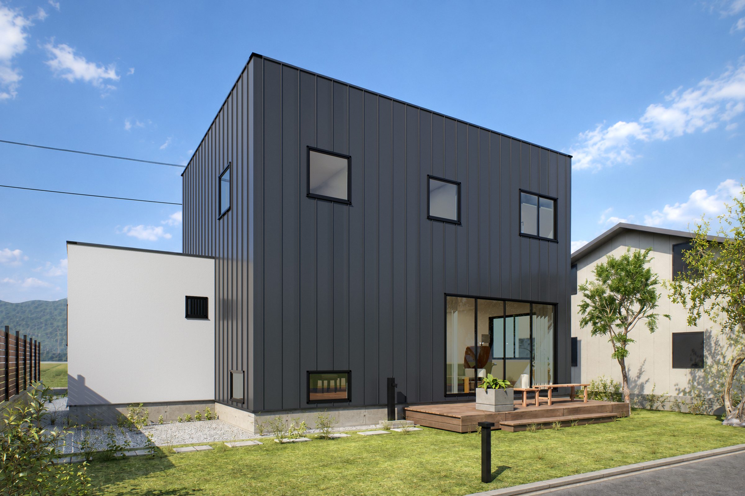 庭の側から見た外観。濃い灰色のガルバリウムの2階建てに、白い塗り壁の平屋